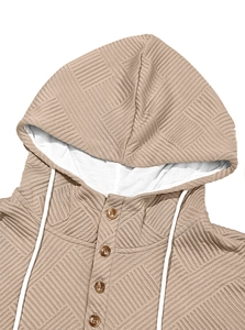 Close-up of brown textured knit hoodie featuring geometric pattern and white drawstrings