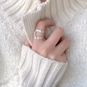 Detailed close-up of wrinkled 925 sterling silver U-shaped ring on model's finger