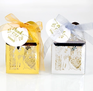 Laser-cut gold and silver wedding favor boxes with Mr & Mrs cutouts and ribbons