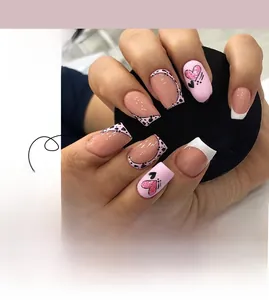 Detail of pink glitter and black heart press-on nail set with French tips and dots