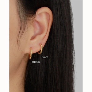 Close-up of 9mm and 10mm gold hoop earrings worn on ear to show size and fit