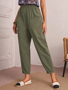 Detail of olive green cotton linen trousers featuring elastic drawstring waist and side pockets