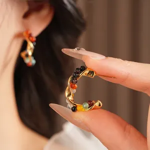 Vintage gold C-shaped earrings with colorful beads and twisted metal detail