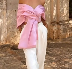 Détail du haut rose satiné avec grand nœud décoratif et design épaules dénudées