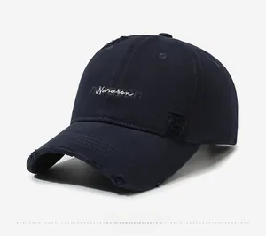 Detail of navy cotton baseball cap showing distressed rips and white Narason embroidery