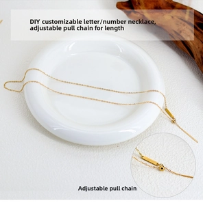 Detail of gold DIY letter necklace showing adjustable sliding buckle and pull chain mechanism