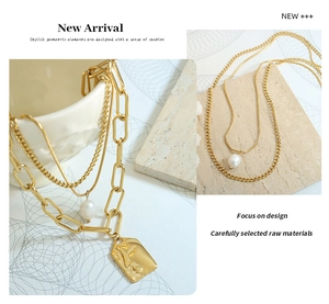 Detailed view of triple-layered gold necklace with pearl and abstract face pendant