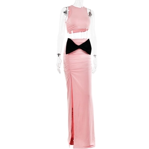 Dettaglio del crop top rosa e gonna a vita alta con spacco laterale e grande fiocco nero