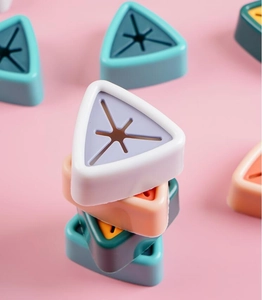 Colorful triangular silicone towel holders with star-shaped openings on pink background
