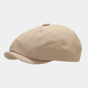Detail view of khaki herringbone fabric texture on retro newsboy cap with top button