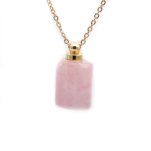 Detail of pink semi-precious stone perfume bottle pendant with gold metal cap on chain
