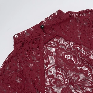 Dettaglio dell'abito in pizzo bordeaux con collo alto e bottone a perla nera sul retro