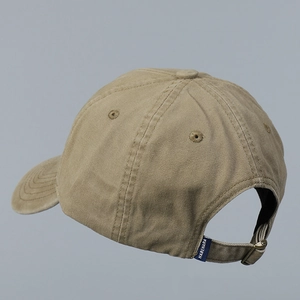 Detail of khaki baseball cap showing adjustable metal buckle and woven side label