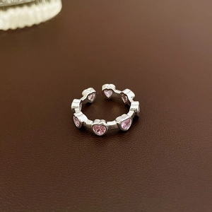 Detailed close-up of pink heart-shaped stones on a silver adjustable open flower ring