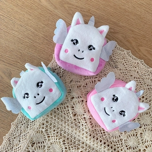 Detail of plush unicorn coin purses with silver wings and cute embroidered faces