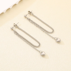 Detailed view of long silver chain earrings featuring polished 3D heart-shaped pendants