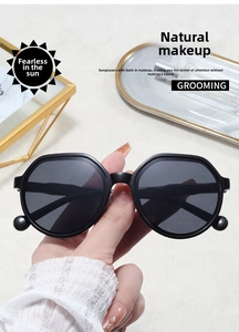 Detail of black oversized sunglasses with unique metal sphere accents on the frame