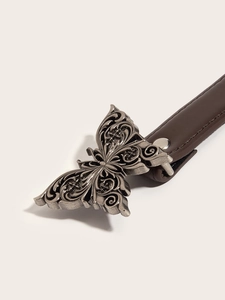 Detail view of a vintage dark silver butterfly metal buckle on a brown leather belt