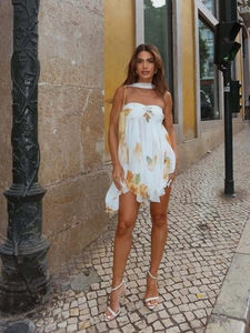 Detail of white floral chiffon mini dress with halter neck tie and layered ruffle hem