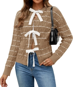 Detail of three white bow-tie fastenings on a brown cable knit cardigan sweater