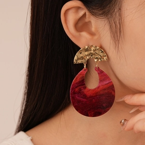 Orecchini a goccia in resina bordeaux con perni in metallo dorato martellato su modella