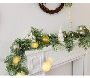 Artificial Christmas garland with warm lights, pine cones, and balls on a white fireplace
