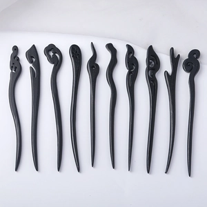 Minimalist black ebony hairpins with hand-carved cloud and branch patterns on white fabric