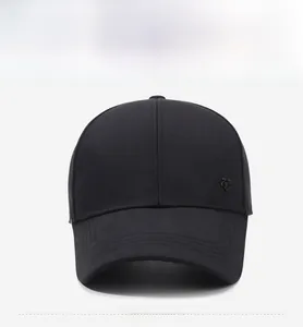 Detail view of black cotton baseball cap with curved brim and metallic logo emblem