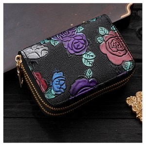 Détail du porte-cartes en cuir avec motif floral en relief et fermeture éclair sécurisée