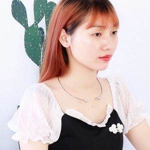Minimalist silver stainless steel open necklace with spherical ends on female model