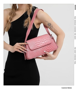Detail of pink croc-embossed shoulder bag showing premium texture and metallic luster
