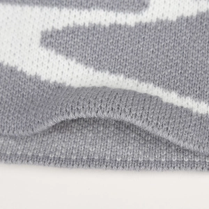 Close-up of soft grey knit fabric with detailed V-pattern texture for winter hats