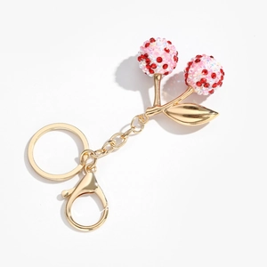 Détail du porte-clés cerise avec strass roses et rouges sur fermoir mousqueton doré