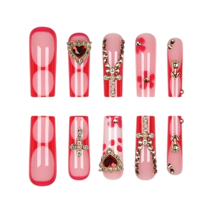 Detail of red French long coffin press-on nails with 3D gold rose and cross charms