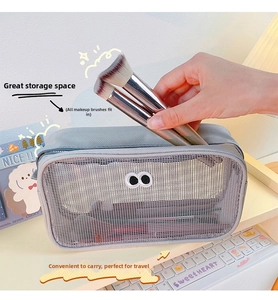 Gray mesh makeup bag with large eye embroidery storing multiple cosmetic brushes