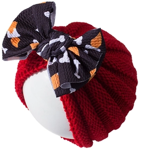 Red baby knit beanie with a large printed bow featuring white bones for Halloween