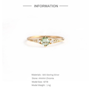 Detail of S925 sterling silver ring featuring a green round zirconia with diamond accents