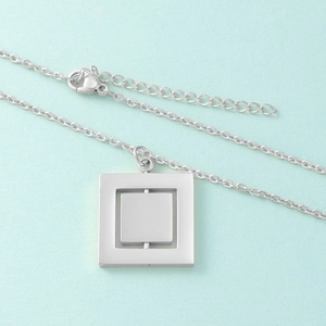 Detail view of the silver rotatable double-layer square pendant and lobster clasp mechanism