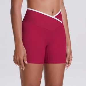 Detail of high-waisted yoga shorts with deep red fabric and white V-shaped crossover waist