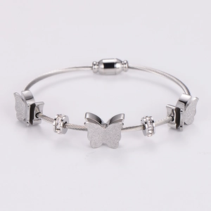 Detail of silver steel cable bracelet with magnetic clasp and zircon butterfly charms