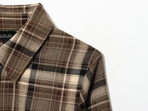 Detailed close-up of brown plaid shirt collar showing stitching and fabric texture