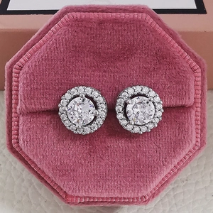 Macro shot of butterfly zircon earrings with white stones in a pink velvet jewelry box
