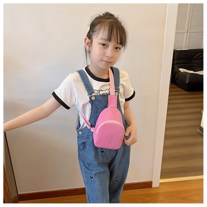 Pink nylon crossbody chest bag shown on child model for size and fit representation
