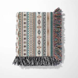 Detail of bohemian throw blanket with geometric patterns and colorful tassel fringes