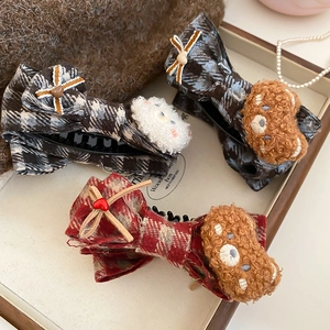 Detailed view of plaid fabric bow hair clips with cute plush bear embroidery patches