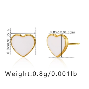 Macro shot showing dimensions and profile of heart-shaped gold-rimmed white earrings