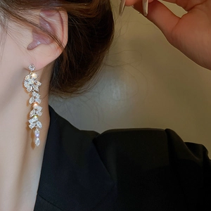 Macro shot of silver leaf tassel earrings with sparkling cubic zirconia on model