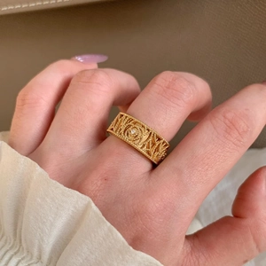 Macro shot of gold-plated twisted rope ring featuring a central sparkling zircon stone