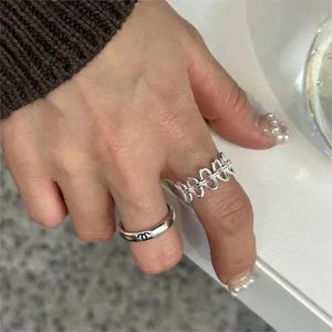 Detailed shot of S925 sterling silver chain ring and minimalist ring on model's hand