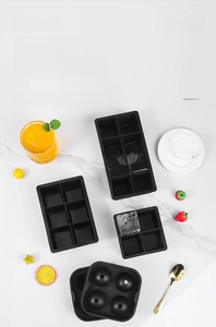 Détails des moules à glaçons en silicone noir disposés sur un plan de travail en marbre